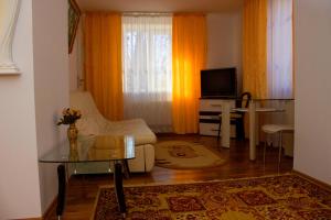 a living room with a glass table and a television at Hotel Confort Drochia in Drochia
