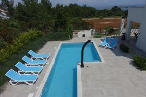 a swimming pool with lounge chairs next to a swimming pool at Villa Mare in Ližnjan