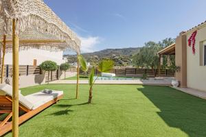 a backyard with a grass yard with a hammock at Seaside Breeze Villa - Beachfront, Private Pool, BBQ in Agia Pelagia