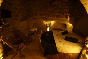 a room with a bed in a cave at Rock Mansion Cappadocia in Nar
