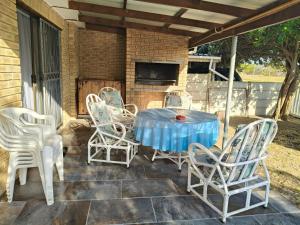 a table and chairs on a patio with a fireplace at Sea Wave Cottage in Pearly Beach