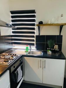 a kitchen with a sink and a stove top oven at Lovely studio centrally located in Peterborough