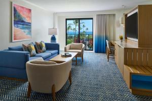 a living room with a blue couch and a tv at OUTRIGGER Kaua'i Beach Resort & Spa in Lihue