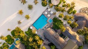 an aerial view of a resort with a pool and palm trees at OUTRIGGER Maldives Maafushivaru Resort in Dhangethi