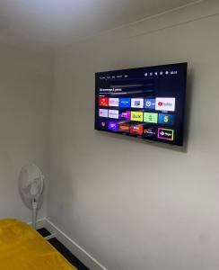 a television on a wall in a bedroom at Lovely studio centrally located in Peterborough