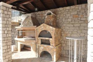 a stone oven with a table and a table at Kerkyra Studios & Apartments in Benitses