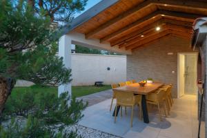 a patio with a wooden table and chairs at Villa Sofija in Vodnjan