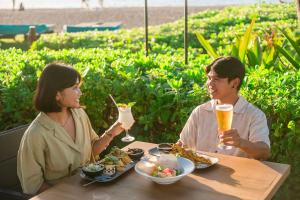 a man and woman sitting at a table with drinks at OUTRIGGER Kāʻanapali Beach Resort in Lahaina