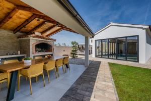 an outdoor patio with a table and chairs and a fireplace at Villa Sofija in Vodnjan