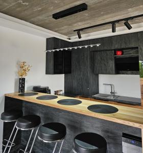 a kitchen with a counter with four sinks and stools at Królowa Beskidu in Słopnice +17 photos