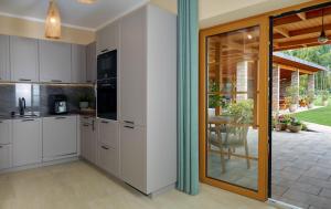 a kitchen with white cabinets and a sliding glass door at Lipowa Przystań in Tarnów Jezierny +10 photos