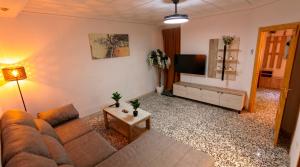 a living room with a couch and a flat screen tv at Ruralux Sierra Castril in Huéscar