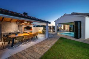 an outdoor kitchen and dining area with a table and chairs at Villa Sofija in Vodnjan