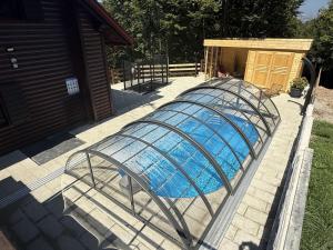 a swimming pool in a metal cage next to a house at Chalet Cozy Bear Cabin by Interhome in Mrkopalj +53 photos