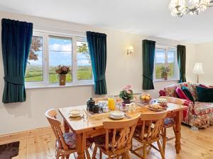 a dining room with a table and chairs and windows at Exmoor View Wootton Courtenay in Minehead