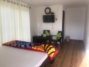 a bedroom with a bed and a table with a chair at The Plum in Mukteshwar +52 photos