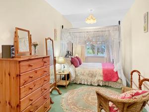 a bedroom with a bed and a dresser and a window at Exmoor View Wootton Courtenay in Minehead