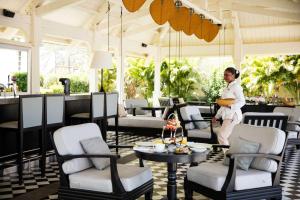a woman standing in a room with chairs and a table at Outrigger Mauritius Beach Resort in Bel Ombre +290 photos