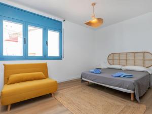 a bedroom with a bed and a yellow chair at Apartment Edificio Candela-2 by Interhome in L'Ametlla de Mar