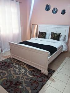 a large white bed in a room with a window at Min cozy homes in Eldoret