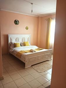 a bedroom with a white bed with yellow pillows at Min cozy homes in Eldoret