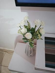 a vase filled with white flowers sitting on a table at Min cozy homes in Eldoret
