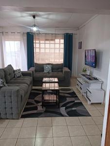a living room with a couch and a tv at Min cozy homes in Eldoret