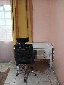 a desk with a chair in a room with a window at Min cozy homes in Eldoret
