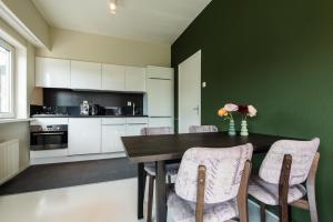 a kitchen with a wooden table with chairs and flowers at Strandweg Appartement in Buren +6 photos