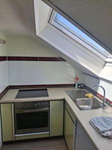 a kitchen with a sink and a stove and a window at Haus Tanja in Neckarbischofsheim