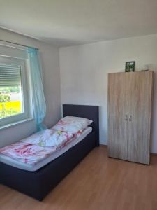 a small bedroom with a bed and a window at Haus Tanja in Neckarbischofsheim