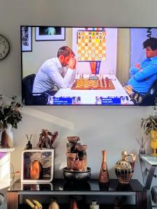 a television hanging on a wall with a chess game at Jupiter in Split
