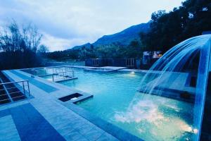 a swimming pool with a fountain in the middle at Srishty Garden Resorts in Tenkāsi
