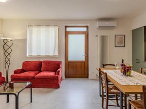 a living room with a red couch and a table at Holiday Home Mimi by Interhome in Verceia +28 photos