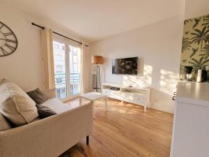 a living room with a couch and a tv at Liv'in Saint Seb, proche de Nantes in Saint-Sébastien-sur-Loire