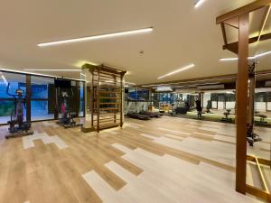 a large room with a gym with wooden floors at Apartamento em Condomínio Frente-Mar com Piscinas, Jacuzzi Aquecida, Sauna, Academia, Brinquedoteca, Churrasqueira na Sacada, Cozinha Completa in Piçarras