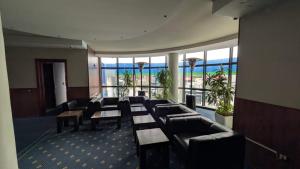 a waiting room with couches and tables and windows at BAR RESTORANT HOTEL ALPET Elbasan in Elbasan