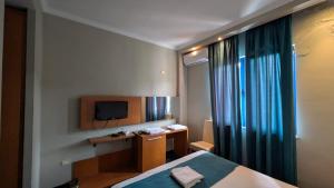 a bedroom with a bed and a desk and a television at BAR RESTORANT HOTEL ALPET Elbasan in Elbasan
