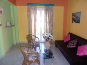 a living room with a couch and a window at Haroula Apartments in Sidari