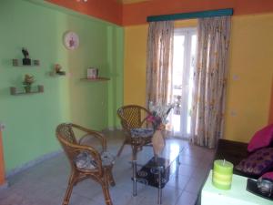 a living room with a couch and chairs and a window at Haroula Apartments in Sidari