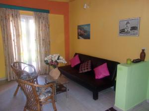 a living room with a black couch and pink pillows at Haroula Apartments in Sidari