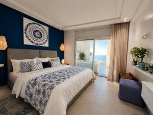 a bedroom with a large bed and a large window at Maison Bella View in Moulay Bousselham