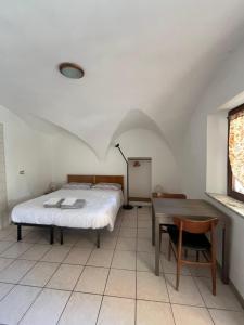 a bedroom with a bed and a table at Lûc Dal Aur in Sùtrio