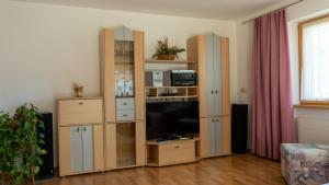 a living room with a large wooden entertainment center with a television at Appartement Wurm- nahe Hochzillertal für Familien in Kaltenbach