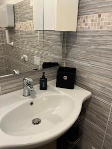 a bathroom with a white sink and a mirror at Lûc Dal Aur in Sùtrio