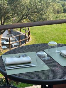a black table with glasses and napkins on it at Tenuta Terre di Bosco Oasi di Relax nel Cilento in San Giovanni a Piro +81 photos