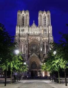 a cathedral lit up at night with trees in front at Hyper centre ville de Reims avec parking in Reims