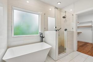 a white bathroom with a tub and a shower at Munice at Trinity Grove in Dallas +16 photos
