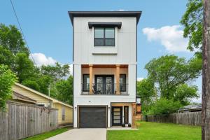 a white house with a black garage at Munice at Trinity Grove in Dallas