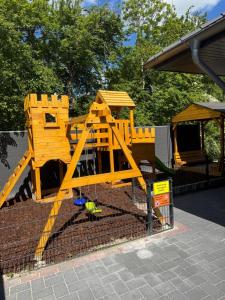 a playground with a yellow wooden play structure at Barrierefreie Ferienwohnung Abendrot in Pewsum, 1 - 4 Personen in Krummhörn